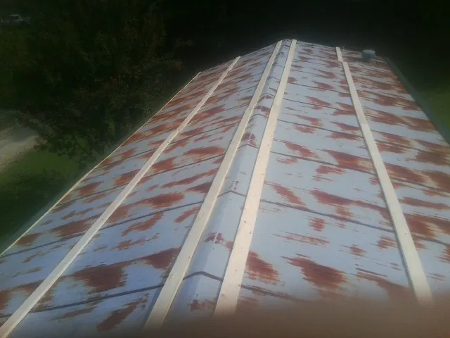 Rusted metal roof panels with new wood purlins before replacement — Storm Damage Roof Repair in Goldendale by Roofing Brothers