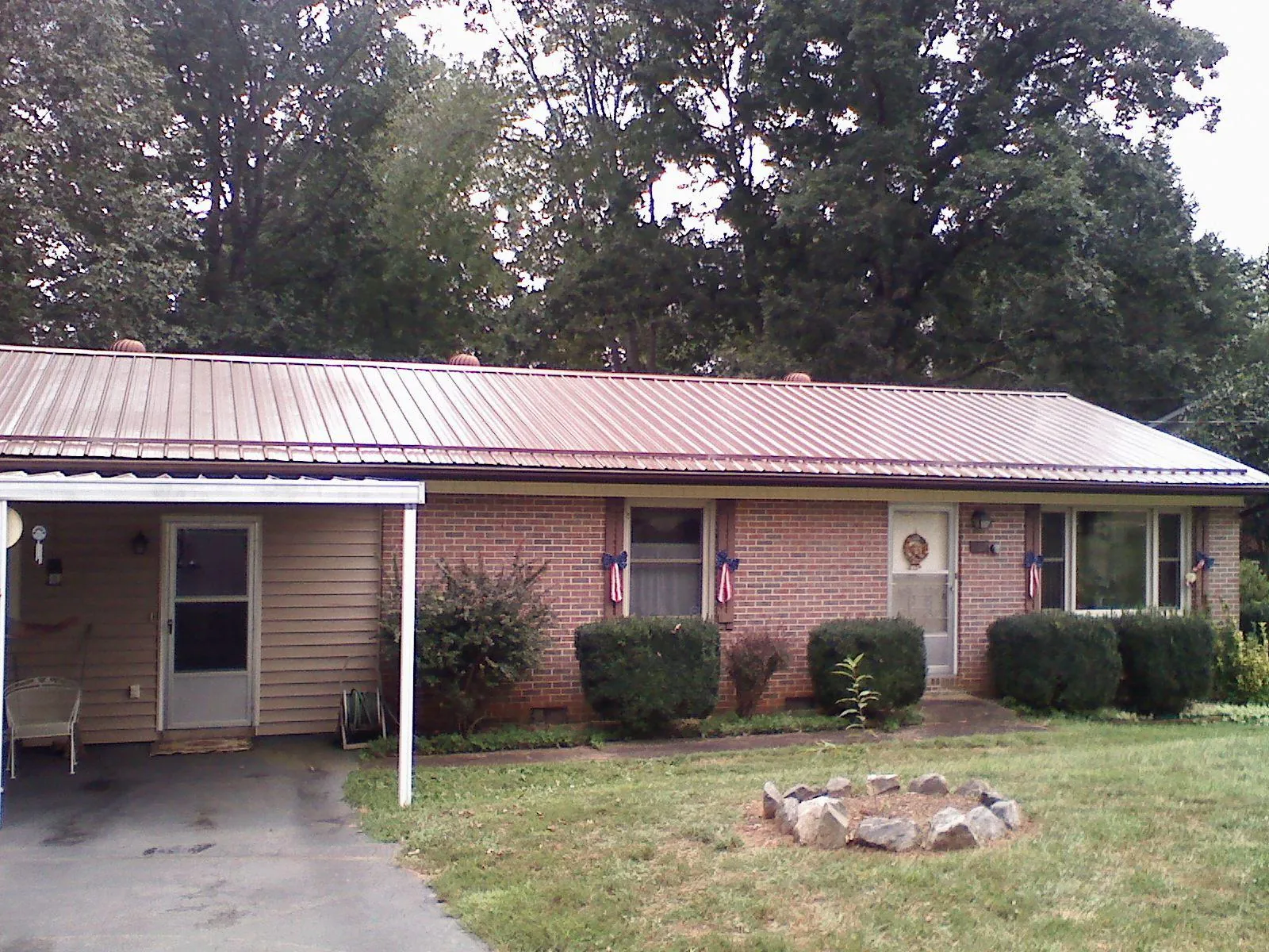 Bronze metal roof and carport on a brick ranch home — Roof Repair work by our crew in Goldendale